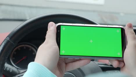 un hombre en un coche con una pantalla verde de teléfono