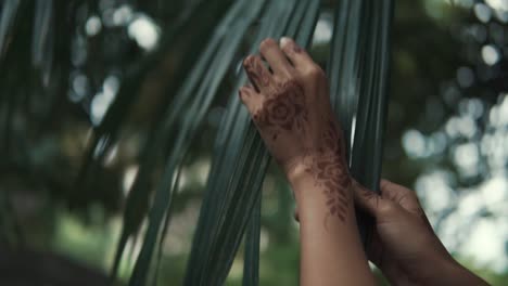 diseño de henna en las manos con hojas de palma