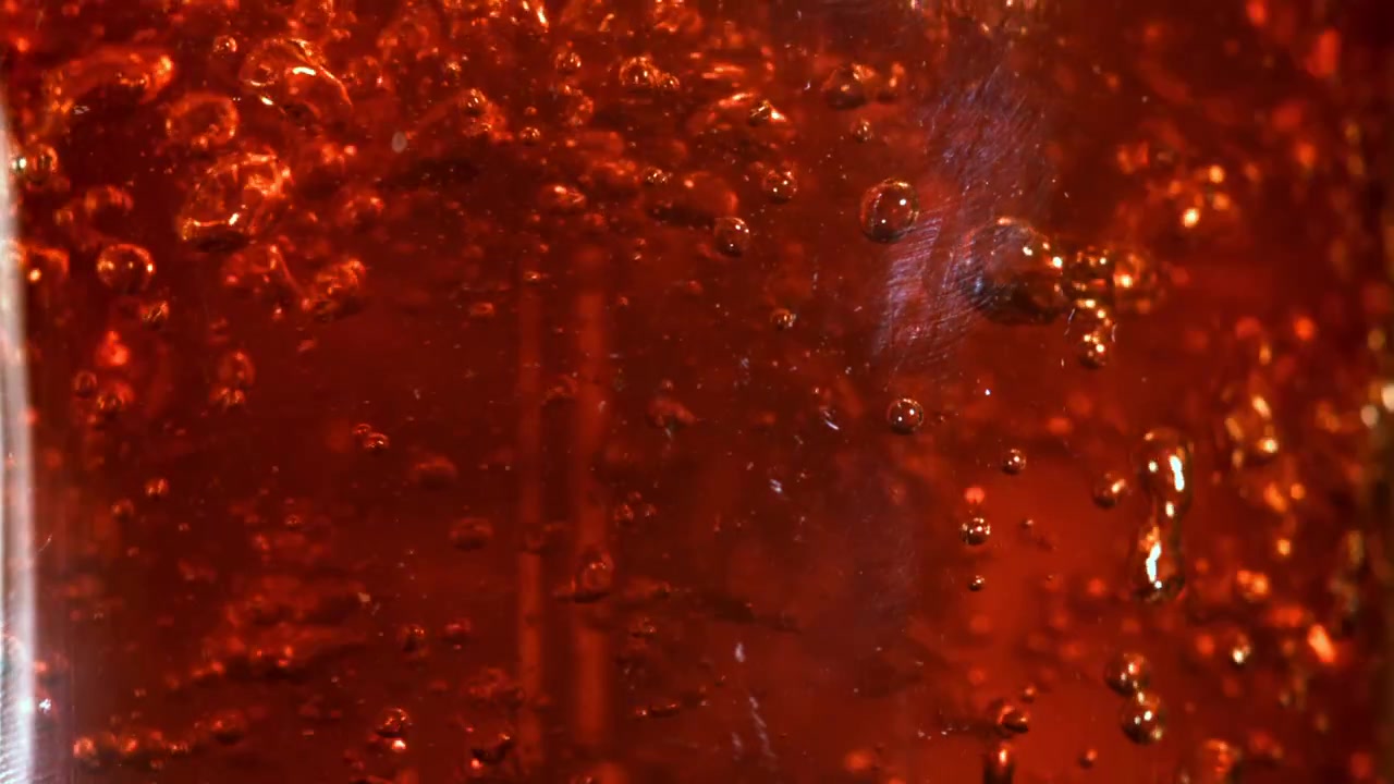 Liquido rosso con bolle in risalita in primo piano