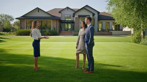 real estate agent showing luxury house to couple