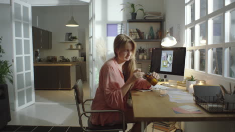 woman lighting aroma candle while working at home