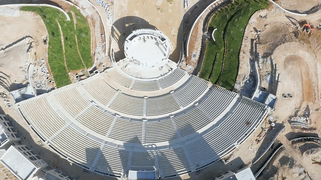 Top down aerial of empty stone Roman amphitheater during the day, rotating shot