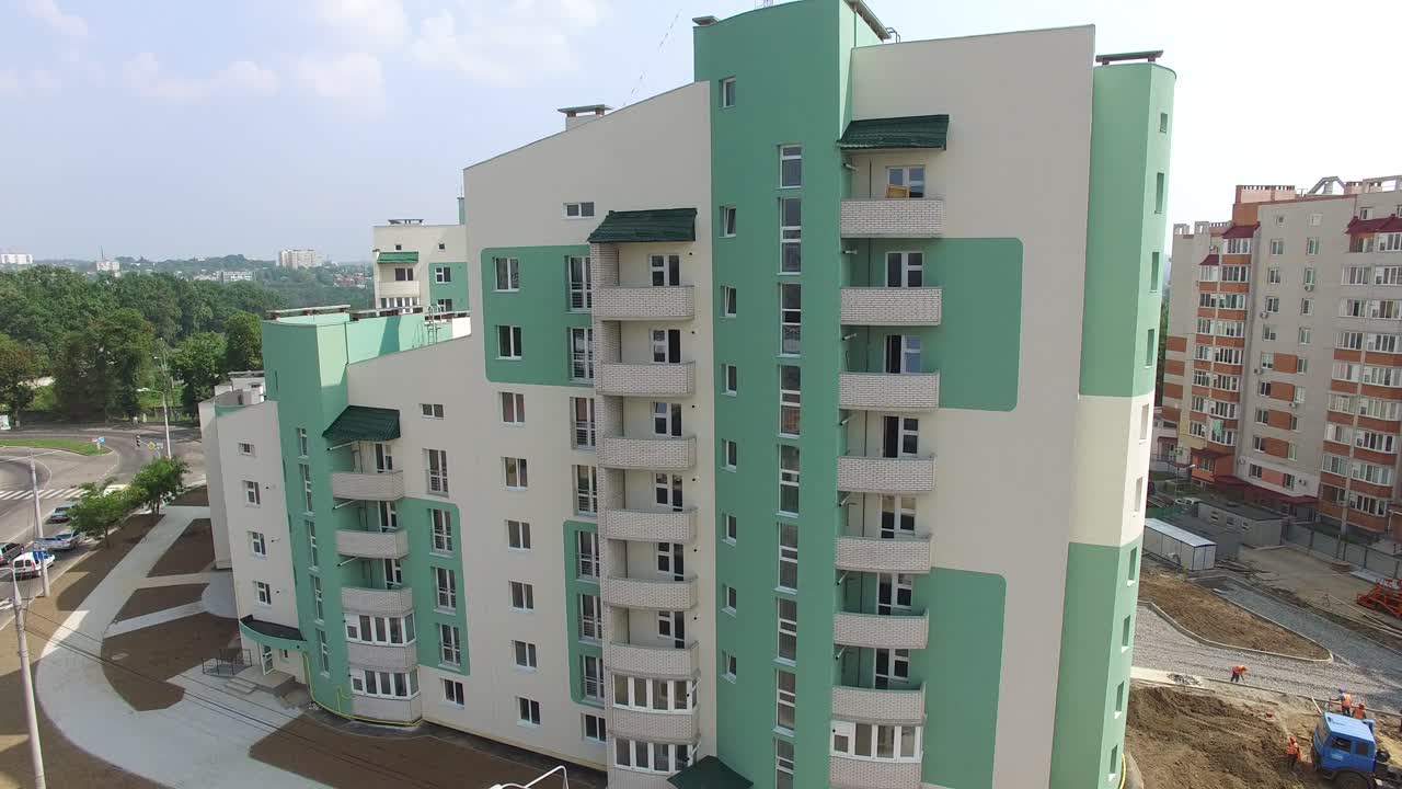Panoramic view of white and green modern building with a new design in the city. Multy-storey building in a new residential complex.