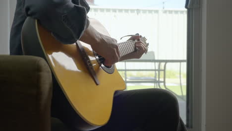 Man-Strumming-Guitar-at-home