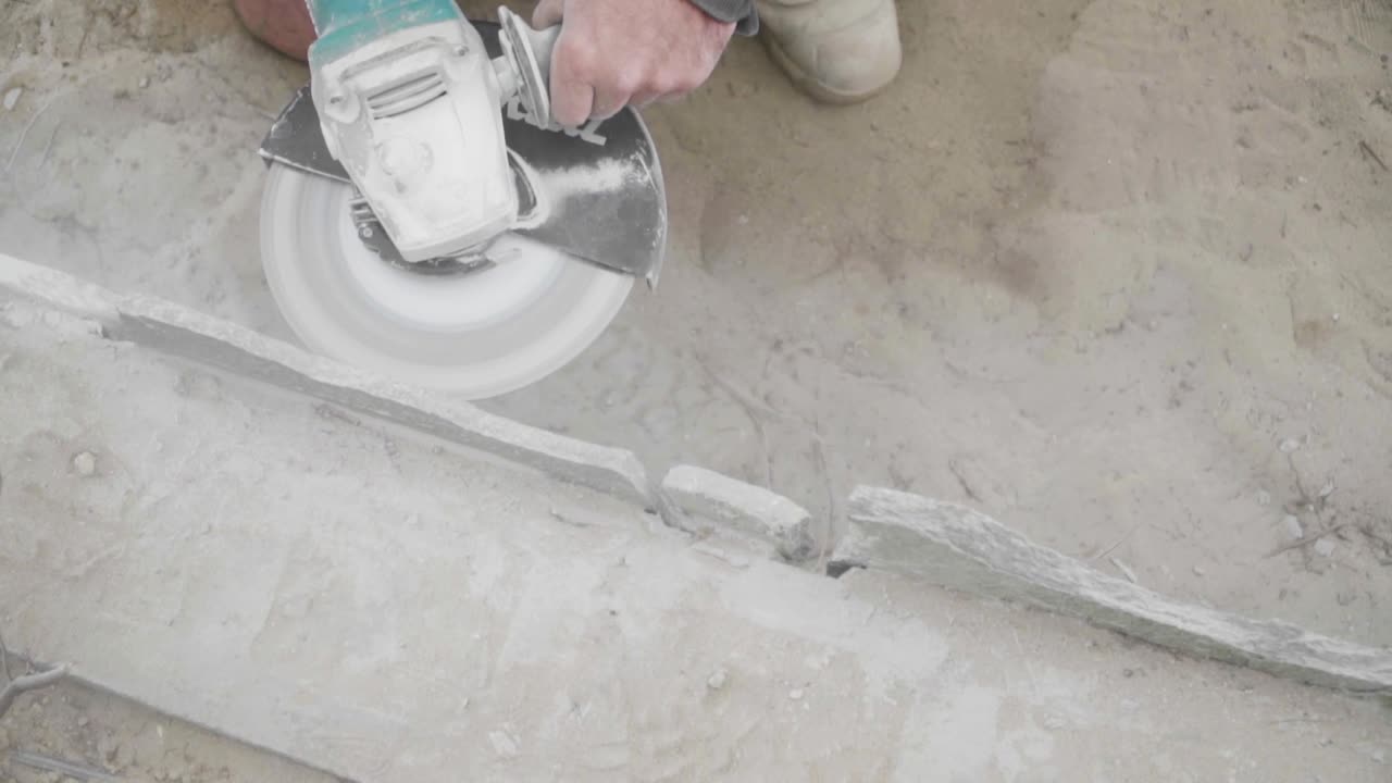 Construction Worker Cutting Stone with Angle Grinder