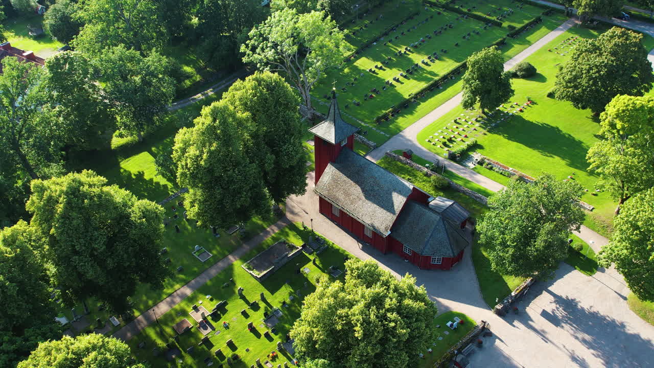 Pull out drone shot of Skalleruds Church next to Lake Naren in the day in West Sweden