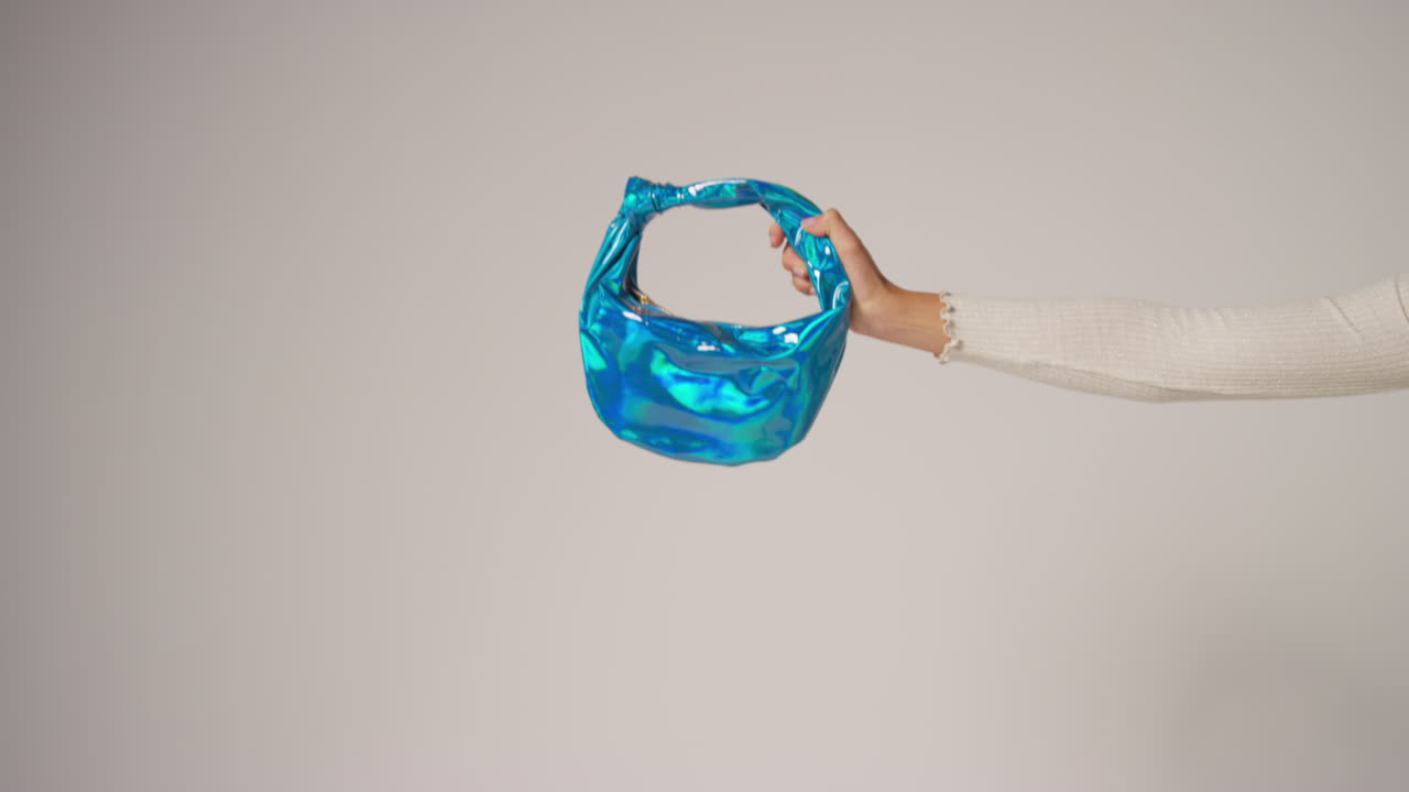 여성 소셜 미디어 인플루언서가 다양한 색의 패션 드백을 들고 사용자 생성 콘텐츠를 생산하는 점프 으로 편집된 클로즈업 비디오