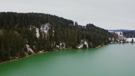 winter landscape of a mountain lake with snow covered forest