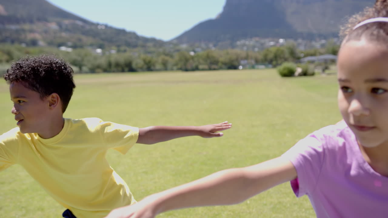 In school, child stretching arms during outdoor physical activity on field