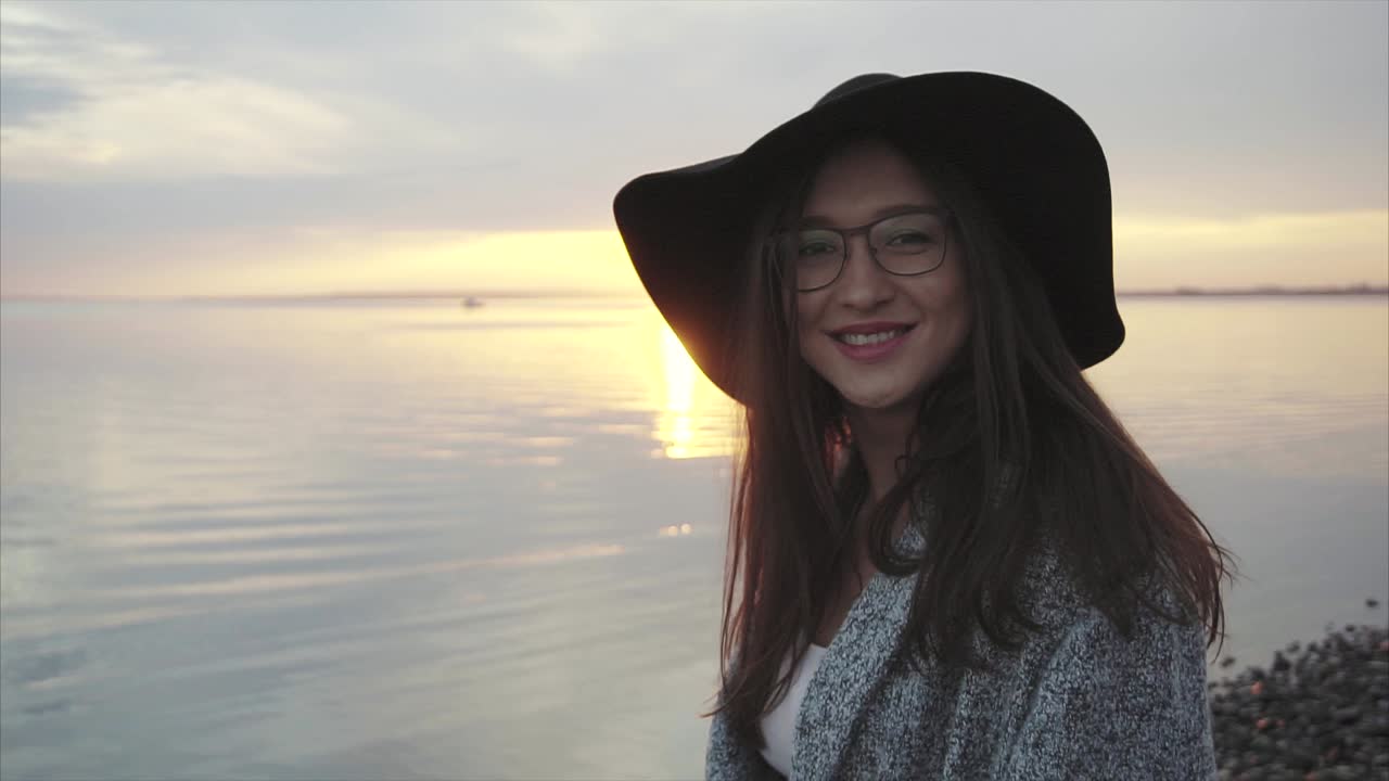 Woman enjoying a sunset by the lake