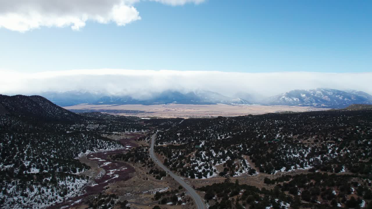 vista aérea de drones de una carretera remota con las montañas rocosas en la distancia