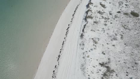 Aerial-view-following-the-shoreline-that-separates-the-ocean-from-the-beach