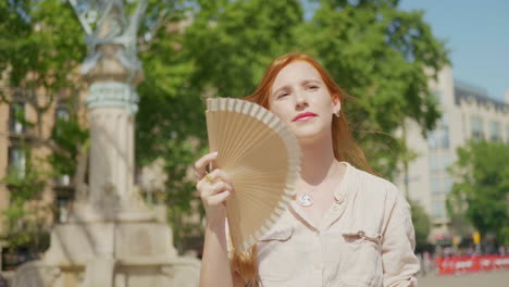 traurige frau, die im freien mit einem ventilator winkt