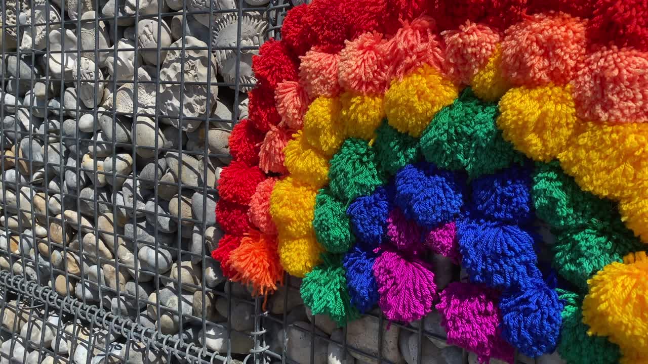 bandas de arco iris y pompones en la pared de piedra para los héroes del nhs y los trabajadores clave que luchan contra el coronavirus covid-19