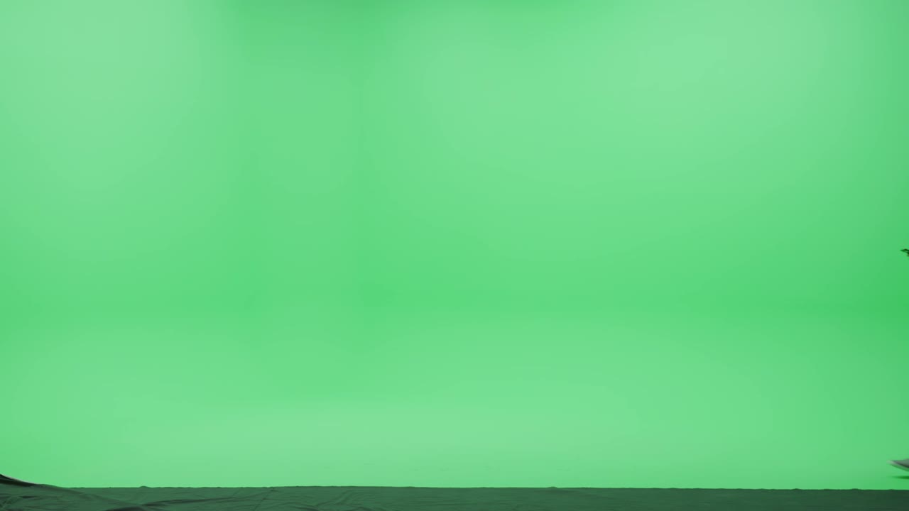 estúdio de tela verde: homem indiano forte vestindo roupas casuais e saco de duffel, usa dispositivo de smartphone, lidando com negócios, falando com uma namorada caminha através da sala de chaves de croma. tiro de câmera de visão lateral