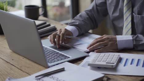 businessman developing business project and analyzing marketing graph data with accounting documents and financial reports on 4k video table.