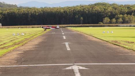 aircraft approaches and lands on a grass-lined runway