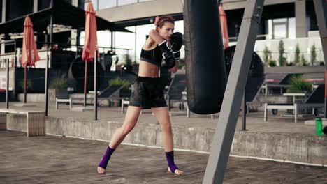 Boxeadora-Atlética-Fuerte-Con-Guantes-Haciendo-Ejercicio-Con-Una-Bolsa.-Hacer-Ejercicio-Al-Aire-Libre.-Entrenamiento-De-Boxeadora-Femenina.-Concepto-De-Autodefensa