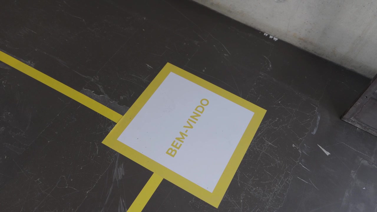 Yellow Bem Vindo welcome marking painted on a scuffed grey concrete industrial floor