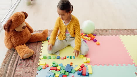 girl child, building blocks and puzzle on floor