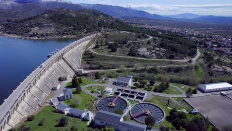 Alta-Vista-Aérea-Sobre-El-Embalse-Y-La-Presa-De-Navacerrada,-Así-Como-La-Planta-De-Tratamiento-De-Aguas-Residuales