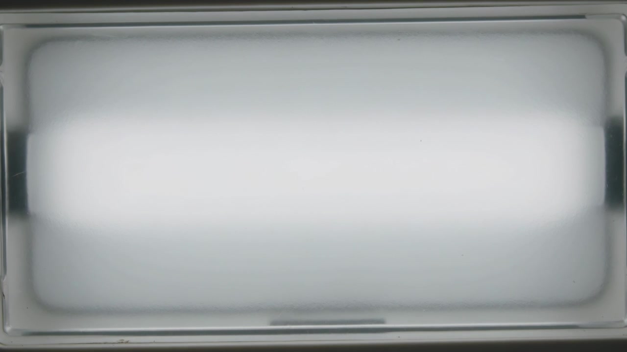 Kamera fanger loftslampe med matteret diffusor, der skifter lysstyrke og afslører kant.