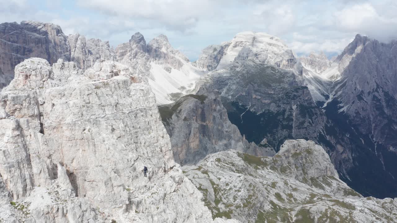 alpinista escalando el pico de la montaña en tre cime, dolomitas, plataforma rodante aérea