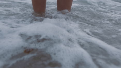 Nahaufnahme-Der-Füße-Und-Wellen,-Die-Barfuß-Planschen.-Eine-Frau-Steht-Am-Strand-Und-Genießt-Einen-Erfrischenden-Urlaub-Am-Meer