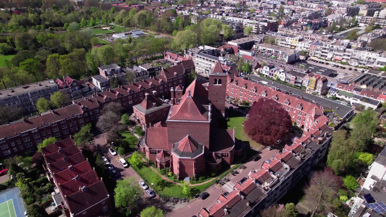 Luftfoto sideværts panorering i boligkvarteret Watergraafsmeer i Amsterdam, Holland, omkring en religiøs bygning. Investering i fast ejendom på det hollandske boligmarked.