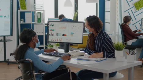 immobilized african entrepreneur working with colleague in new normal office