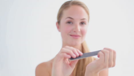 mujer sonriente usando una lima de uñas