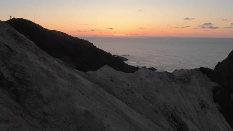 drone flight over a cliff into the sunset