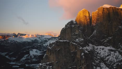 a drone tilts over a group of sella in the snowy dolomites