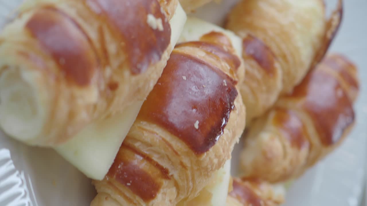 Primo piano di deliziosi croissant dorati su un piatto bianco