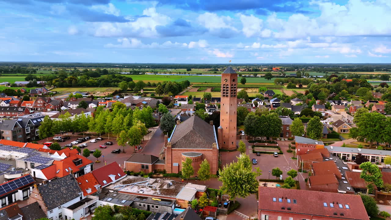 Approaching a brick building of Saint Lawrence church. Aerial perspective on the beautiful scenery of Vierlingsbeek, Netherlands at daytime