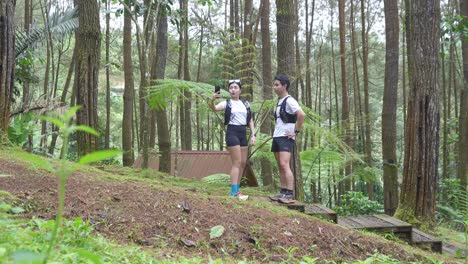 asian couple taking photos during outdoor adventure in forest