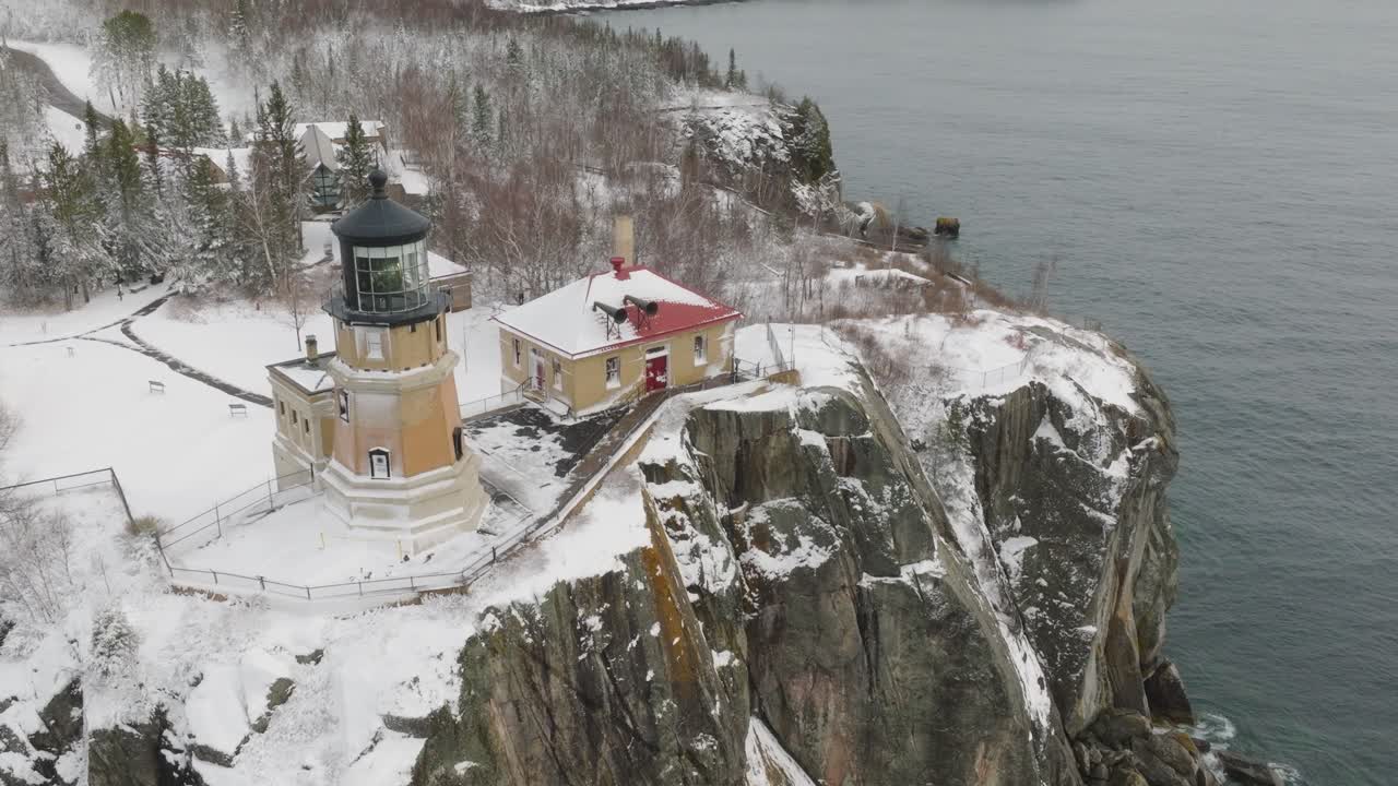 Split Rock Lighthouse On Icy Cliff On The North Shore Of Lake Superior In Minnesota, USA. aerial descending shot
