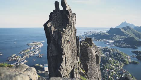 persona escalando en un acantilado rocoso extremadamente peligroso en noruega, svolværgeita lofoten