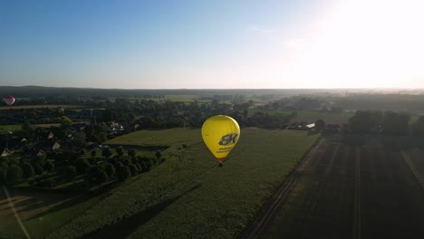 Globo-Aerostático-Amarillo-Volando-Sobre-Los-Campos-Cerca-Del-Glamping-Parc-Buitengewoon-En-Países-Bajos