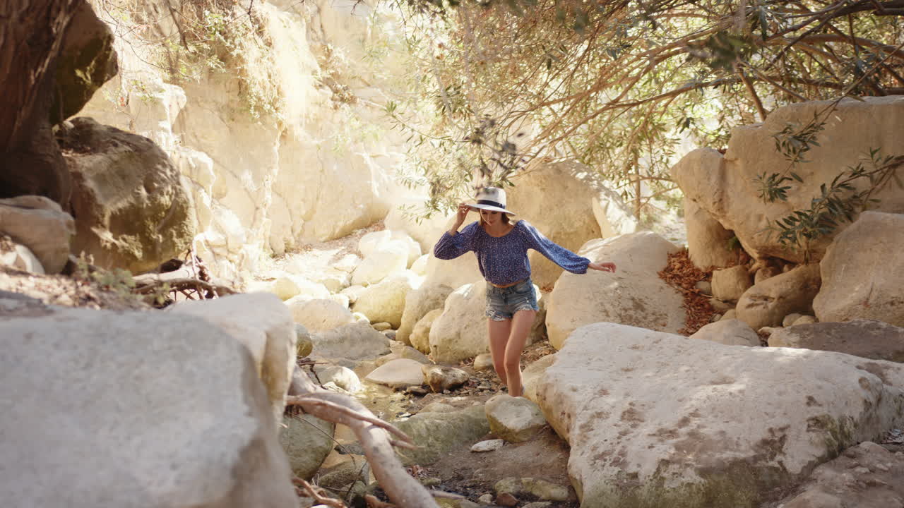 mujer caminando a través de un arroyo del cañón
