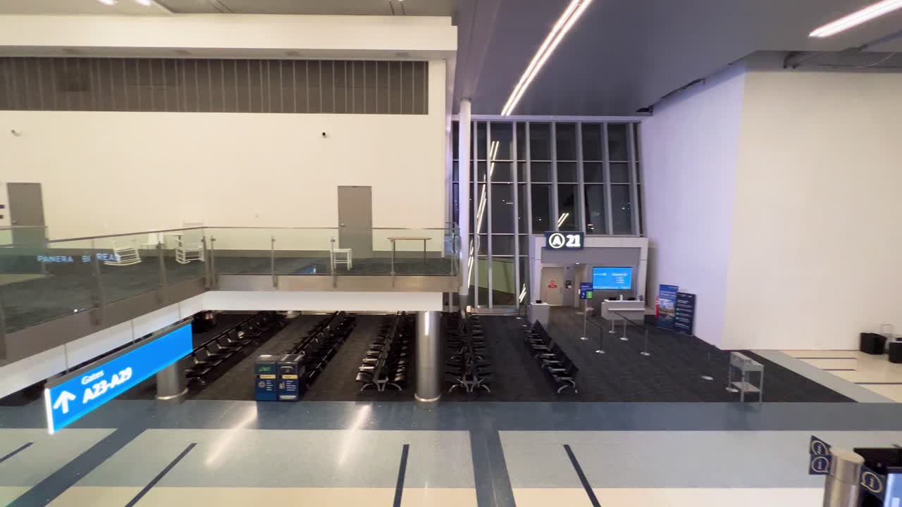 Panoramica lenta del terminal A all'aeroporto CLT di notte, vuoto e senza persone, con i tabelloni dei voli e i cambi di gate sullo sfondo