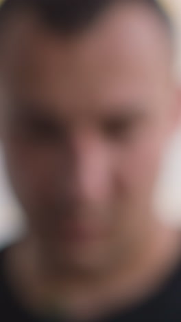 confused man takes mobile phone from windowsill and looks at screen with message sitting in light spacious office extreme close view slow motion