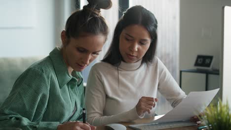 Dos-Mujeres-Trabajando-Y-Analizando-Algo-En-La-Computadora-En-Casa