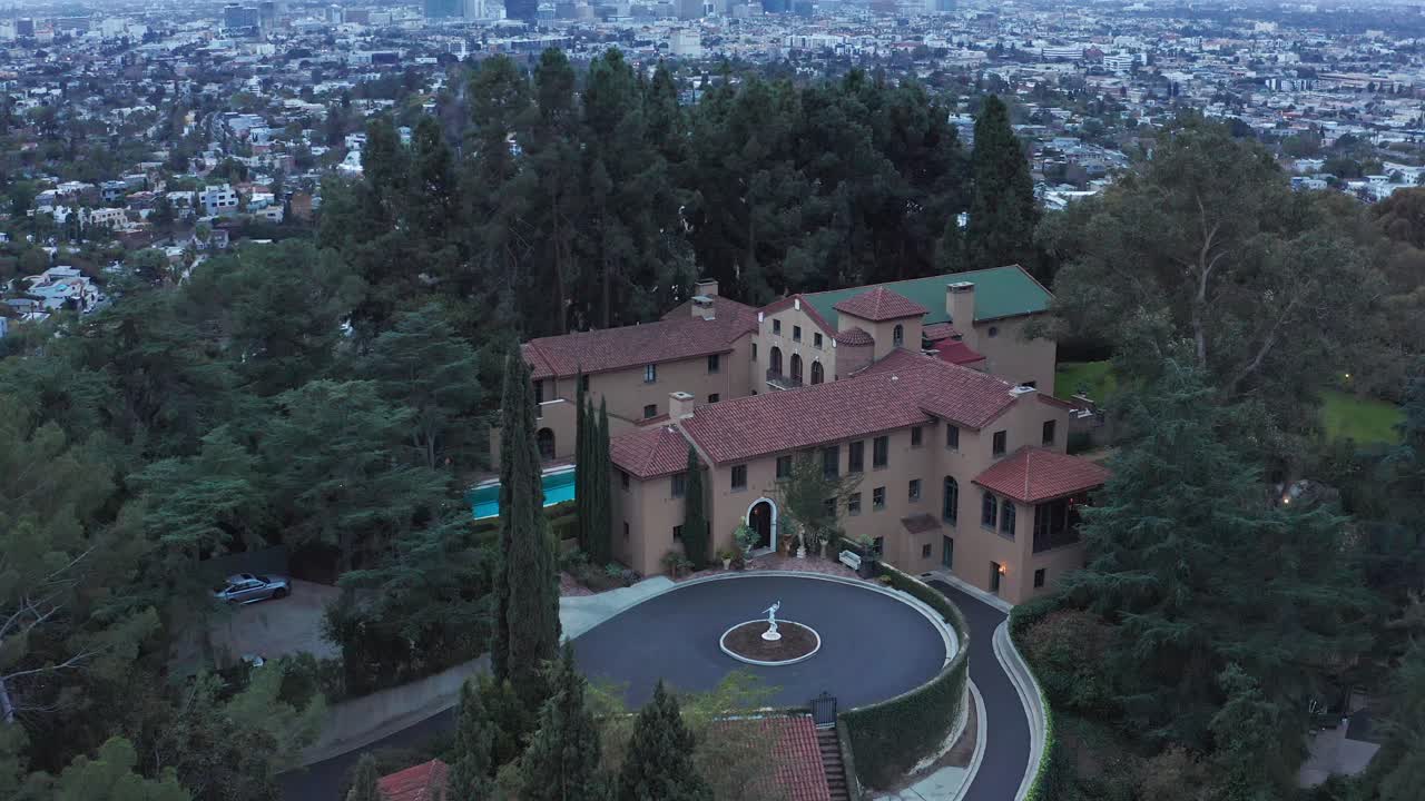 Rising and tilting down aerial shot of the sprawling Paramour Estate perched on top of a hill in Hollywood, California. 4K