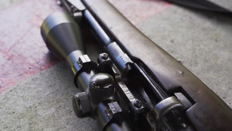 closeup details of wooden shotgun with rifle scope at shooting range