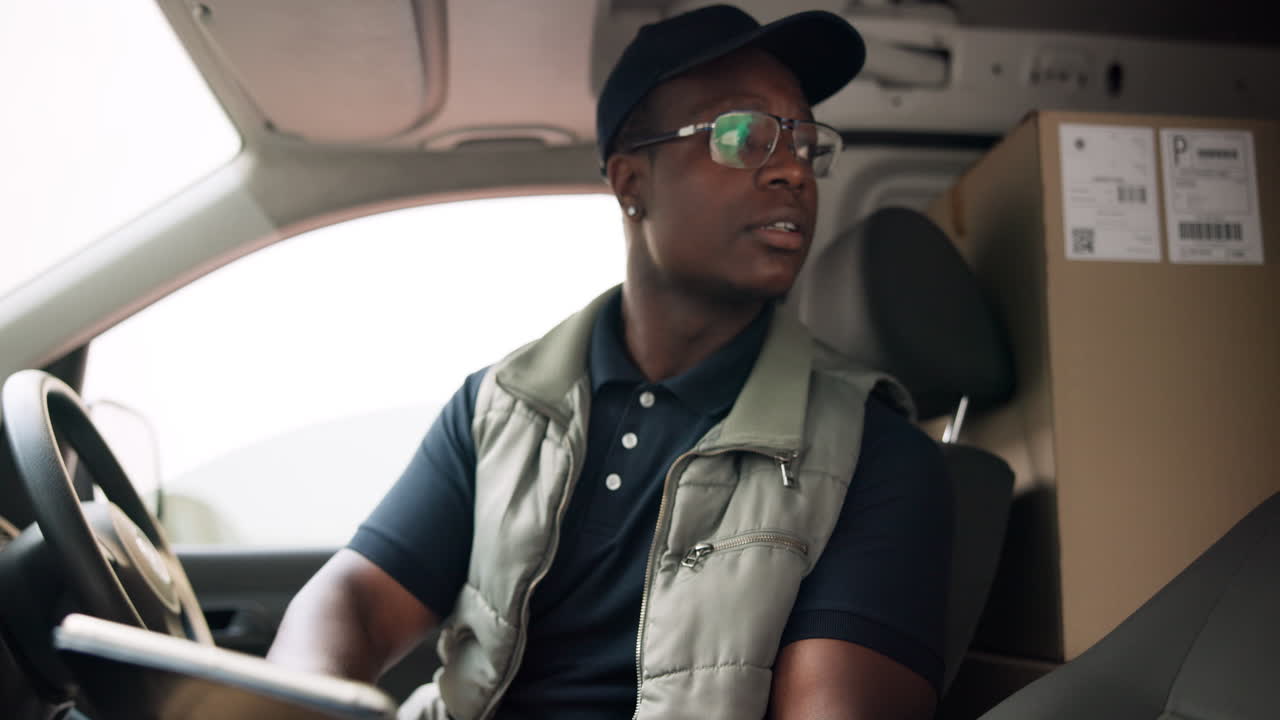 Delivery driver checking packages in van