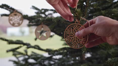 hanging wooden plywood christmas decoration on green tree