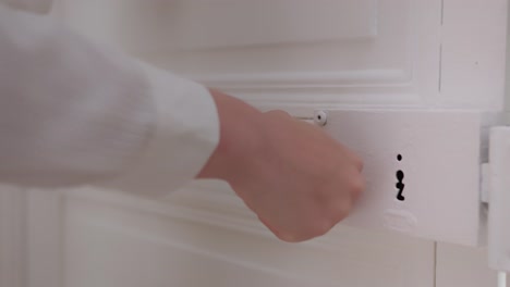 close up of female hands trying to open locked bedroom door, unsuccessfully