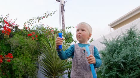 boy playing with bubble wand in garden 4k