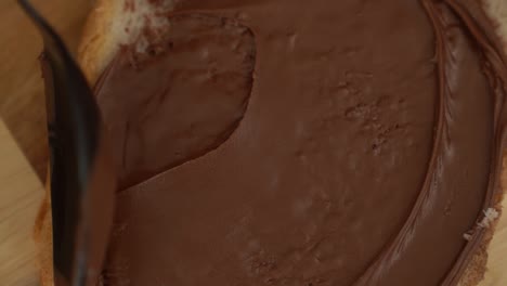 spreading chocolate spread onto fresh toast